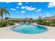 Community pool with lounge chairs surrounded by lush landscaping and a secure fence at 7145 Lakeside Dr, Sarasota, FL 34243