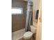 Modest bathroom featuring tiled shower, toilet, and curtain at 718 Roma Rd, Venice, FL 34285