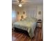 Cozy bedroom with wood floors, a ceiling fan, and a decorative paisley bedspread at 718 Roma Rd, Venice, FL 34285