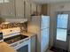 Traditional kitchen featuring tile backsplash, white cabinets, and appliances at 718 Roma Rd, Venice, FL 34285