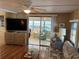 Living room with flat screen tv, ceiling fan, and sunroom access at 718 Roma Rd, Venice, FL 34285