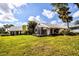 Lush backyard featuring a screened-in patio with a beautiful lawn and tropical palm trees at 734 Brightside Crescent Dr # 18, Venice, FL 34293