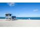 Beautiful beach view with lifeguard station, people relaxing, and clear blue sky at 734 Brightside Crescent Dr # 18, Venice, FL 34293