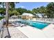 Community pool featuring lounge chairs and a shaded area, surrounded by lush landscaping and a secure fence at 734 Brightside Crescent Dr # 18, Venice, FL 34293