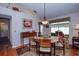 Dining area adjacent to living room has wood floors, a pendant light, and a slider to lanai at 734 Brightside Crescent Dr # 18, Venice, FL 34293