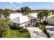 Beautiful exterior elevation showcases mature landscaping, neutral paint, and a white tile roof at 734 Brightside Crescent Dr # 18, Venice, FL 34293