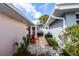 Cozy patio with red chairs, a small grill, and lush tropical landscaping offering private outdoor space at 734 Brightside Crescent Dr # 18, Venice, FL 34293