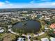 Aerial view of community featuring a lake, surrounded by well-maintained homes and verdant landscaping at 734 Sugarwood Way, Venice, FL 34292