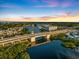 Breathtaking aerial view of a coastal city featuring a bridge, waterfront condos, and serene waterways at sunset at 734 Sugarwood Way, Venice, FL 34292