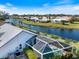 Aerial view of a home featuring a pool with a screened enclosure and views of the surrounding community at 734 Sugarwood Way, Venice, FL 34292