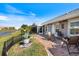 Beautiful backyard featuring a brick patio, lush green lawn, lake view, and inviting seating area at 734 Sugarwood Way, Venice, FL 34292