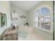 Bright bathroom featuring a large window, soaking tub, and decorative accents at 734 Sugarwood Way, Venice, FL 34292