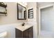 Modern bathroom features dark wood vanity, light countertop, mirror, and white wainscoting at 734 Sugarwood Way, Venice, FL 34292