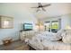 Cozy bedroom with light blue walls, a floral-patterned bedspread, and a view of the water from the sliding glass door at 734 Sugarwood Way, Venice, FL 34292