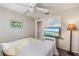 Simple bedroom with a bed, TV, grey and yellow linens, neutral walls, and carpet at 734 Sugarwood Way, Venice, FL 34292