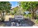 Welcome sign to The Lakes community set amidst mature trees and natural landscaping at 734 Sugarwood Way, Venice, FL 34292