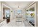 Bright dining area with white table, chairs, tile flooring, a ceiling fan and a view of the lake from sliding doors at 734 Sugarwood Way, Venice, FL 34292