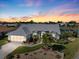 Stunning home exterior with a well-manicured lawn, beautiful landscaping, and a picturesque sunset backdrop at 734 Sugarwood Way, Venice, FL 34292