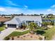 An eye-level view of a home with a white exterior, lush landscaping, and an adjacent screened-in pool and waterfront area at 734 Sugarwood Way, Venice, FL 34292