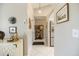 Hallway with white tile flooring, leading to the kitchen with stainless steel appliances at 734 Sugarwood Way, Venice, FL 34292