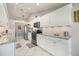 Well-lit kitchen with white cabinets, stainless steel appliances, and ample countertop space at 734 Sugarwood Way, Venice, FL 34292