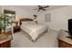 Cozy bedroom featuring carpeted floors, a ceiling fan, and charming rattan furnishings at 748 White Pine Tree Rd # 208, Venice, FL 34285