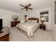 Bedroom features natural light, a ceiling fan, rattan furnishings, and carpeted floors at 748 White Pine Tree Rd # 208, Venice, FL 34285