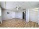 Comfortable bedroom featuring light-colored walls, ceiling fan and wood-look floors at 7903 Hyde Park Ave, North Port, FL 34287