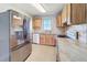 Bright kitchen with stainless steel fridge, wooden cabinets and light countertops at 7903 Hyde Park Ave, North Port, FL 34287