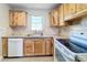 Well-equipped kitchen featuring wooden cabinets, white appliances, and light countertops at 7903 Hyde Park Ave, North Port, FL 34287