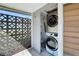 Laundry area on screened porch offering a stacked washer and dryer with shelving at 7903 Hyde Park Ave, North Port, FL 34287