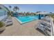 Large community pool surrounded by lounge chairs and lush tropical landscaping at 805 Montrose Dr # 203, Venice, FL 34293