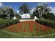 Welcoming sign for The Plantation Golf & Country Club with vibrant red flowers and manicured landscaping at 805 Montrose Dr # 203, Venice, FL 34293