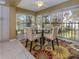 Dining area with a glass table, 4 chairs, and a bright rug, offering beautiful views of the surrounding landscape at 805 Montrose Dr # 203, Venice, FL 34293