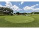 Scenic view of a manicured green with surrounding trees and a serene pond under a partly cloudy sky at 805 Montrose Dr # 203, Venice, FL 34293