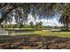 Picturesque golf course view with a pond, sand trap, and lush green landscape framed by trees and blue sky at 805 Montrose Dr # 203, Venice, FL 34293