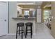 Modern kitchen featuring a breakfast bar with two stools and stainless steel appliances at 805 Montrose Dr # 203, Venice, FL 34293