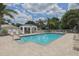 Community pool area with clear blue water surrounded by tropical landscaping and comfortable lounge chairs at 805 Montrose Dr # 203, Venice, FL 34293