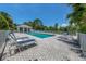 Community pool surrounded by lounge chairs and tropical landscaping creating the perfect place to relax and unwind at 805 Montrose Dr # 203, Venice, FL 34293