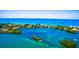 Breathtaking aerial view of waterfront homes with vibrant turquoise waters and lush green islands at 807 Lucille Ave, Nokomis, FL 34275