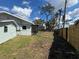 Fenced backyard with lush green grass and mature trees, creating a private outdoor oasis at 807 Lucille Ave, Nokomis, FL 34275