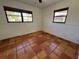 Bedroom featuring terra cotta flooring and natural light from two windows at 807 Lucille Ave, Nokomis, FL 34275