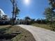 Charming single-story home with a gravel driveway and mature landscaping under sunny sky at 807 Lucille Ave, Nokomis, FL 34275