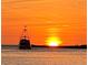 A boat cruises towards the sunset over a calm ocean, with a fiery orange and yellow sky backdrop at 807 Lucille Ave, Nokomis, FL 34275