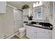 Bathroom featuring a sleek vanity, framed mirror, and a glass-enclosed shower at 8475 Chesapeake Ave, North Port, FL 34291