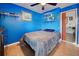 Bedroom boasting bright blue walls, decorative shelves, and stylish furnishings at 8475 Chesapeake Ave, North Port, FL 34291