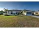 Charming single-story home featuring a well-manicured lawn, tropical landscaping, and an attached two-car garage at 8475 Chesapeake Ave, North Port, FL 34291