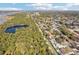 Expansive aerial shot showcasing a residential area near a lake, lined with mature trees and canals at 9790 Parkwood Ct, Seminole, FL 33777