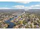 An aerial view showing properties along a river with canal access, lush trees and blue skies at 9790 Parkwood Ct, Seminole, FL 33777