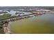 Aerial view of a lakeside with a causeway and a mix of urban and natural landscape at 9790 Parkwood Ct, Seminole, FL 33777